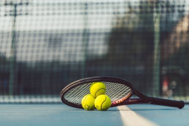 Akrilik mavi yüzey üzerinde profesyonel bir raket üç tenis top