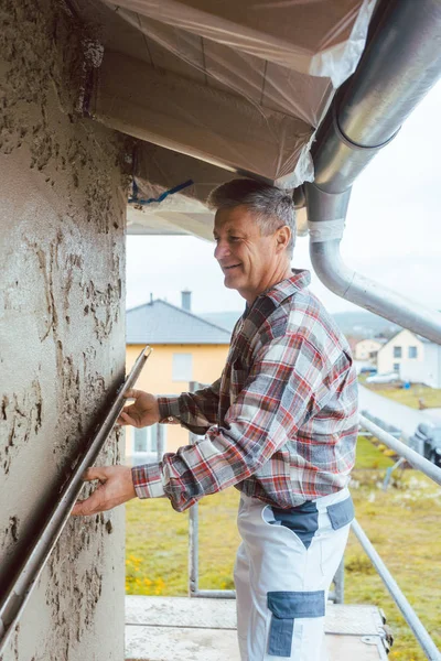 Gipser glättet Putz an einer Fassade — Stockfoto