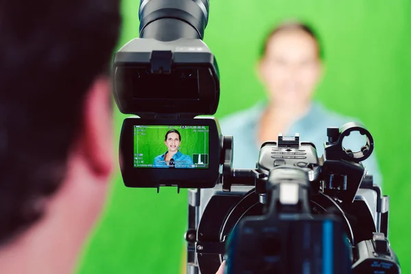 Kamera richtet sich auf eine Nachrichtenfrau oder Reporterin im grünen Studio — Stockfoto