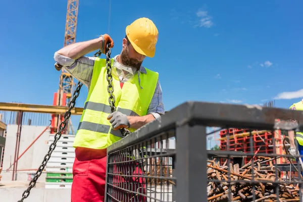 Zuverlässiger Arbeiter überprüft die Sicherheitsverriegelung eines Hakens — Stockfoto