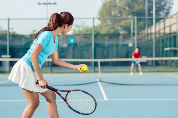 Profi-Spielerin lächelt beim Aufschlag während Tennis-Match — Stockfoto