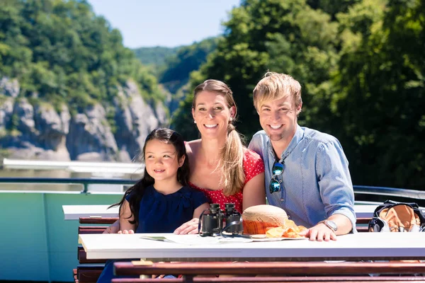 Famiglia in crociera sul fiume guardando le montagne dal ponte della nave — Foto Stock