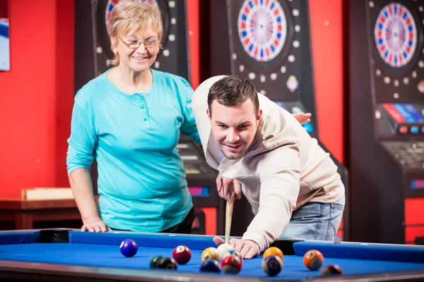 Mother looking at her son playing billiard — Stock Photo, Image