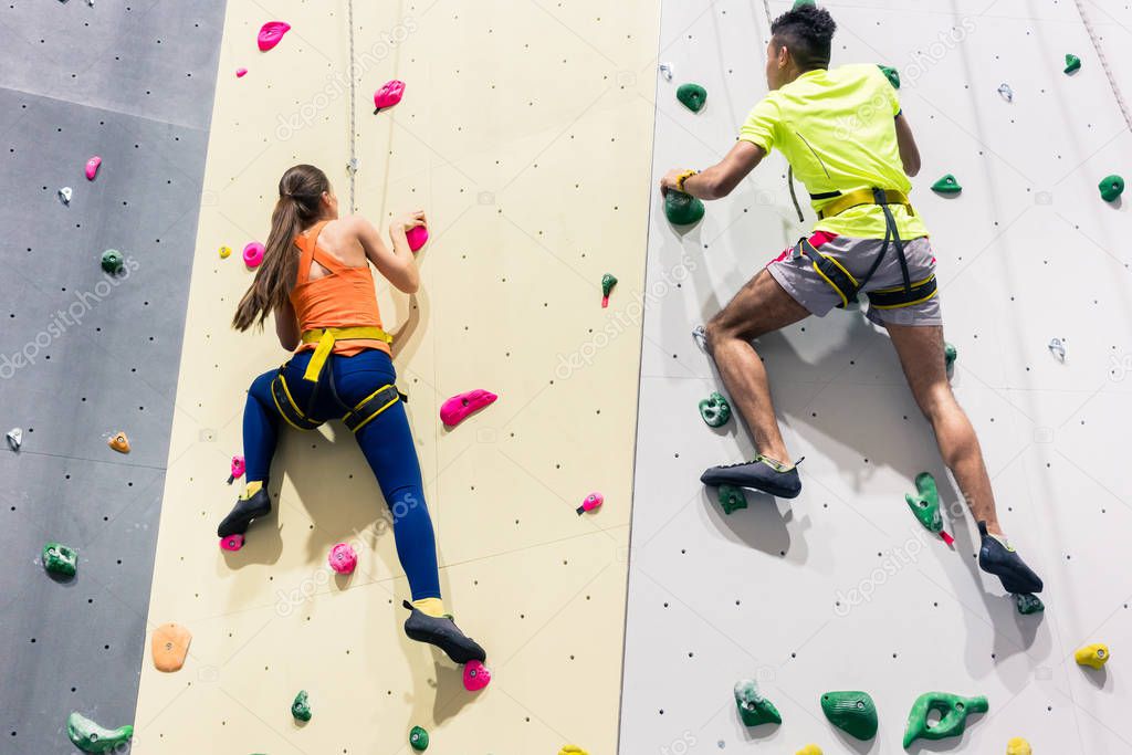 Sporty people climbing wall