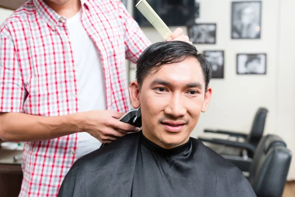 Barber cutting mans hair