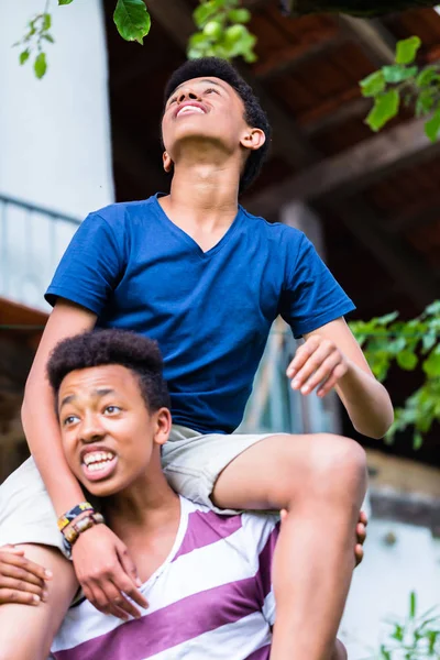 Jongen zit op friendss schouder — Stockfoto