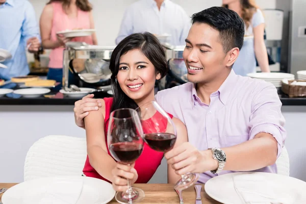 Jovem casal feliz brindar copos de vinho tinto — Fotografia de Stock