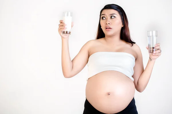 Těhotná žena v ruce držel sklenice mléka a vody — Stock fotografie