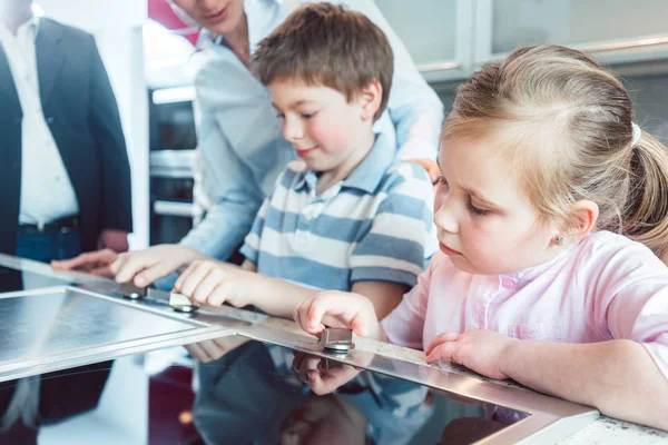 I bambini che controllano la nuova cucina che i loro genitori stanno per comprare — Foto Stock