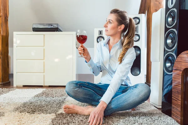 Woman having glass of wine in front of Hi-Fi speakers — Stock Photo, Image