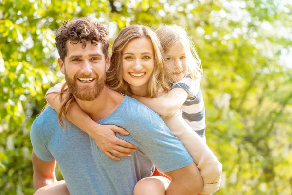 Hombre fuerte apoyando a su familia llevando esposa e hijo a cuestas —  Fotos de Stock