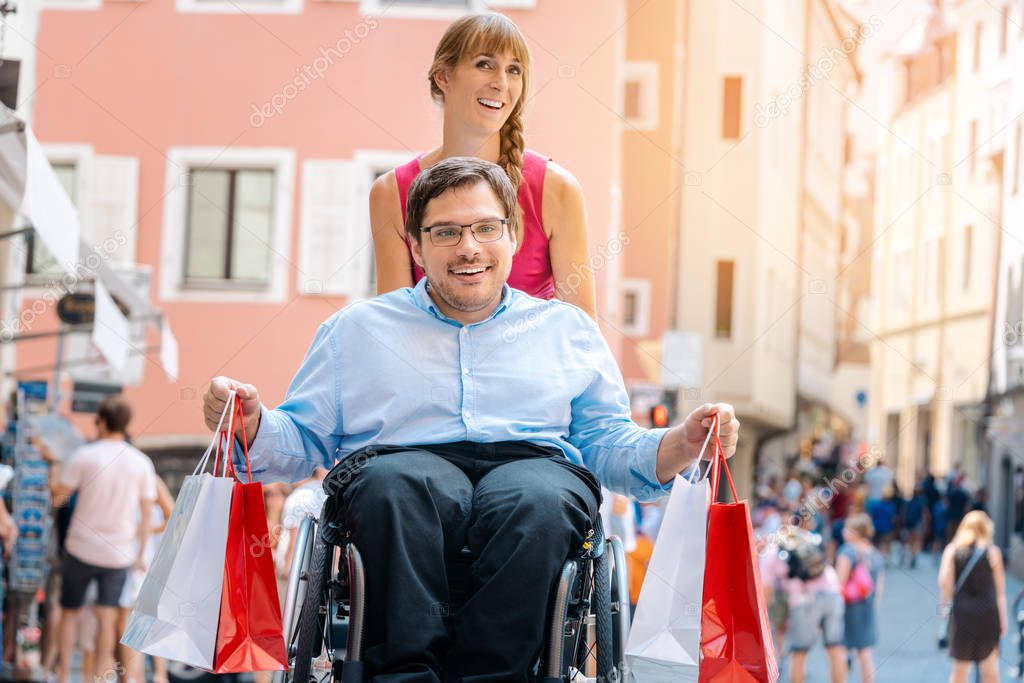 Man in wheelchair being pushed by his friend on a shopping trip