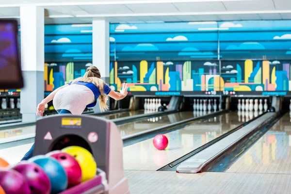 Zadní pohled mladé ženy bowling — Stock fotografie