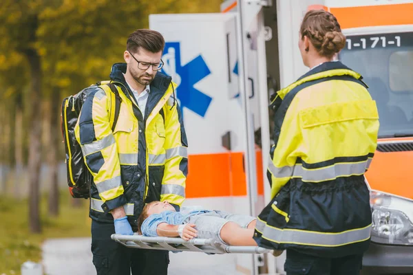 Médicos poniendo niño herido en camilla después de accidente —  Fotos de Stock