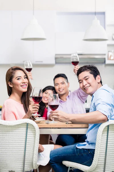 Jovem casal desfrutando de bebidas com amigos — Fotografia de Stock