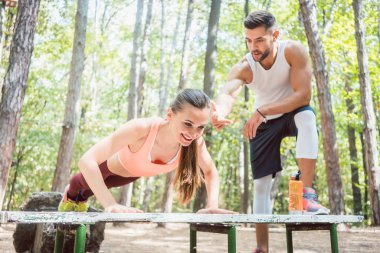 Sportif kadının destekli açık bir spor salonunda yapması