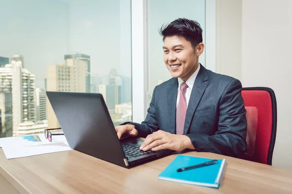 Porträt eines Geschäftsmannes, der auf Laptop schaut — Stockfoto