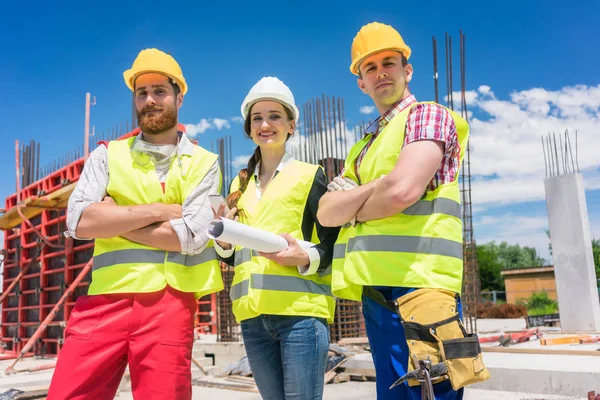 Портрет трьох впевнених і надійних молодих працівників на будівельному майданчику — стокове фото