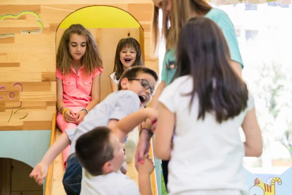 Filles mignonnes souriant pendant le temps de jeu supervisé dans un jardin d'enfants moderne — Photo