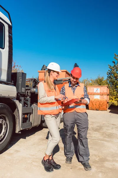 Arbeiter unterschreibt Papiere, um Abrissschuttcontainer geliefert zu haben — Stockfoto