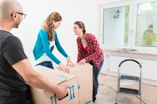 Group of friends unpacking the cardboard box — Stock Photo, Image