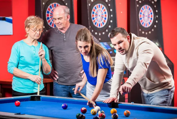 Young and mature couple playing billiard — Stock Photo, Image