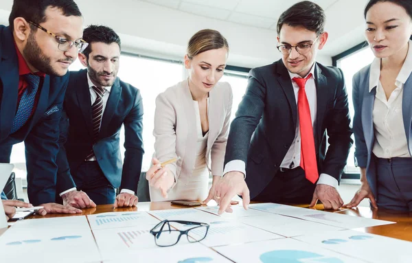 Equipo de empresarios analizando números y gráficos — Foto de Stock