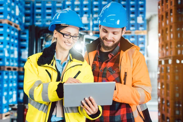Woman and man as workers in logistics center using computer — Stock Photo, Image