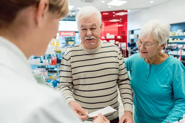 Farmacista ottenere prescrizione slittamento da coppia anziana — Foto Stock