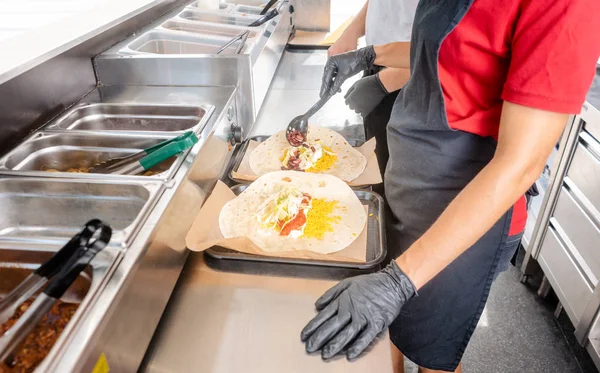 Wanita menyiapkan burrito dalam truk makanan — Stok Foto