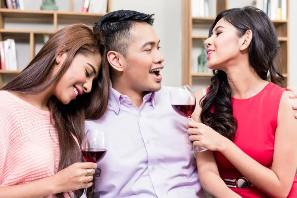 Man enjoying wine with two girlfriends — Stock Photo, Image
