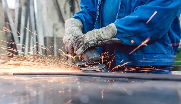 Robotnik w fabryce metalurgicznej szlifowania przedmiotu obrabianego z iskier — Zdjęcie stockowe