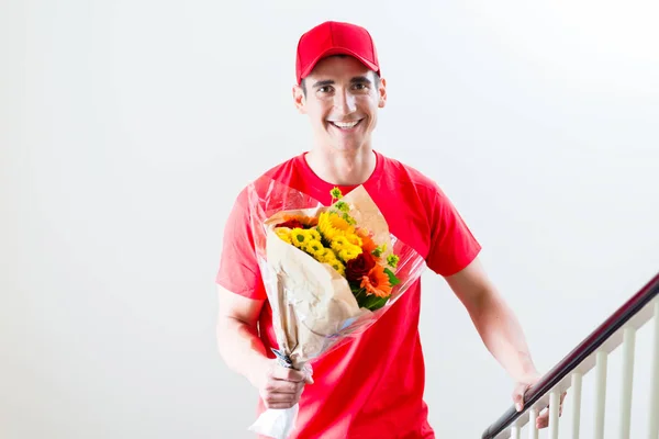 Entrega hombre llevando ramo de flores — Foto de Stock