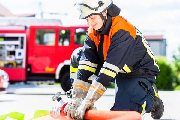 Fire fighter connecting hoses — Stock Photo, Image