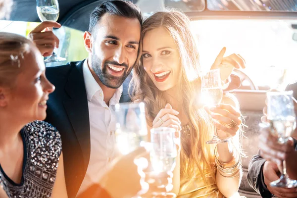 Casal comemorando festa na limusine com amigos — Fotografia de Stock