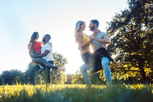 Twee koppels dansen Kizomba tijdens zonsondergang in een park — Stockfoto