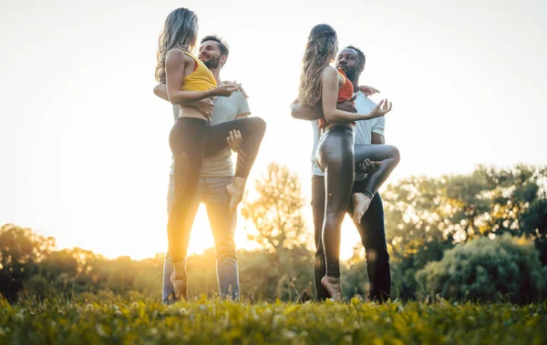 Dois casais dançando kizomba durante o pôr do sol em um parque — Fotografia de Stock