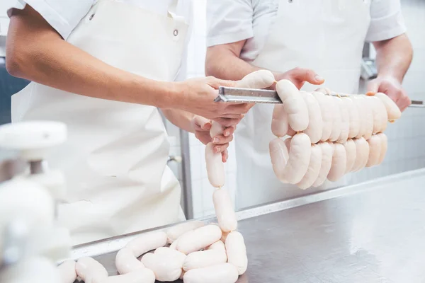 Werknemers werken in de slagerij produceren worstjes persoonsgebonden op balk — Stockfoto