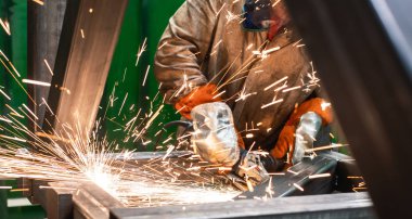 Açı öğütücü ile çalışan metal işçisi