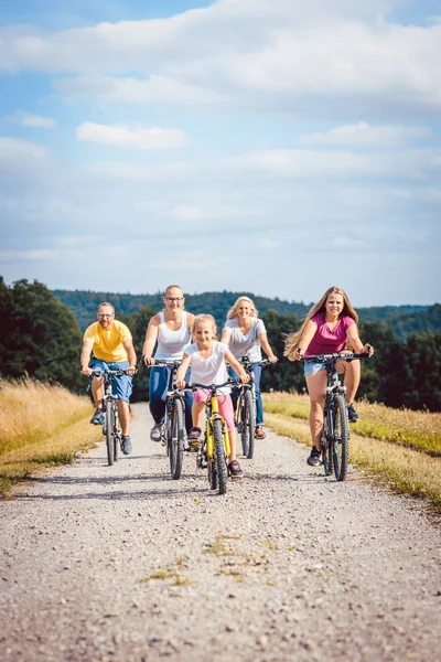 Familie rijden hun fietsen op de middag op het platteland — Stockfoto