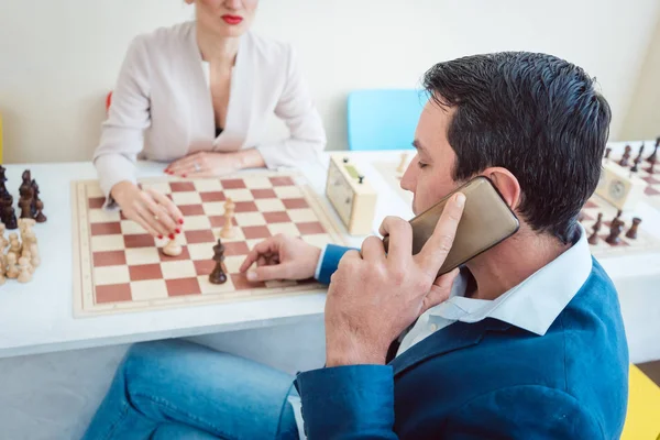 Uomini d'affari che giocano a scacchi con l'uomo al telefono — Foto Stock