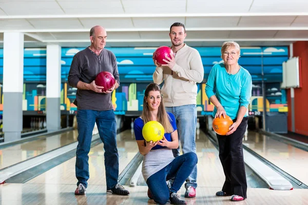 Smiling family holding bowling ball — Stock Photo, Image