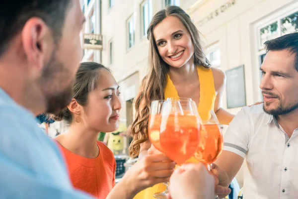 Quatro amigos comemorando juntos com uma bebida refrescante de verão — Fotografia de Stock