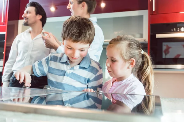 I bambini che controllano la nuova cucina che i loro genitori stanno per comprare — Foto Stock