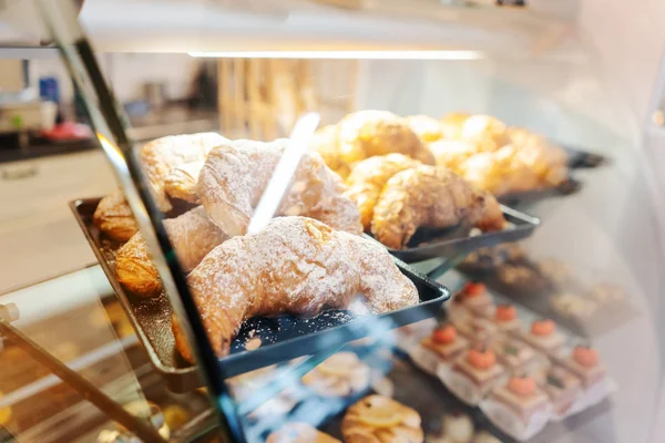 Confectioner shot through glass display in her shop — Stock Photo, Image