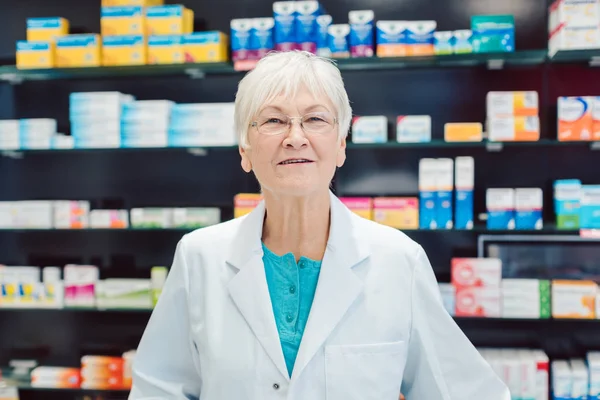 Farmacéuticos experimentados frente a estantes en farmacia —  Fotos de Stock