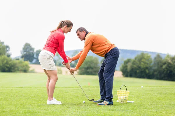 Golfista dando entrenamiento a la mujer para tomar un tiro — Foto de Stock