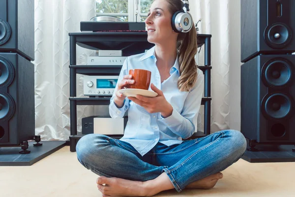 Женщина пьет кофе и слушает музыку — стоковое фото