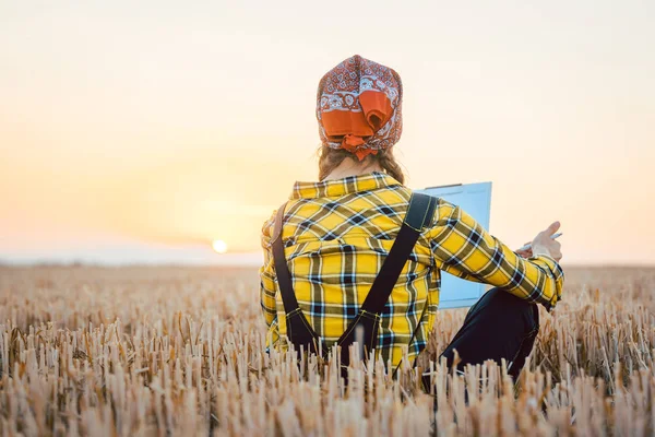 Farmer woman calculating harvest yield after a long day — Stock Photo, Image