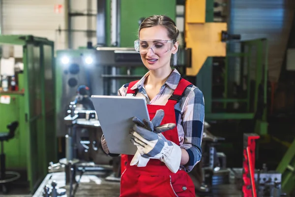 Trabajadora con tableta delante de la máquina — Foto de Stock